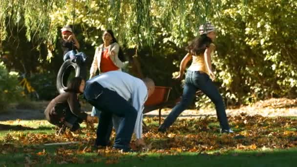 Сім'я грає з осіннім листям — стокове відео