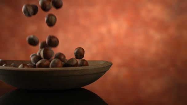 Hazelnuts falling into bowl — Stock Video