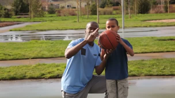 Отец учит сына играть в баскетбол — стоковое видео