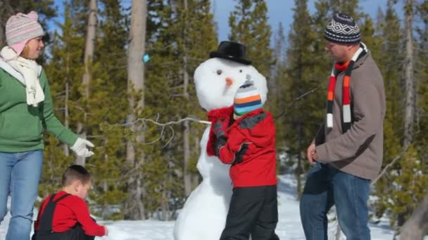 Familjen att göra en snögubbe — Stockvideo