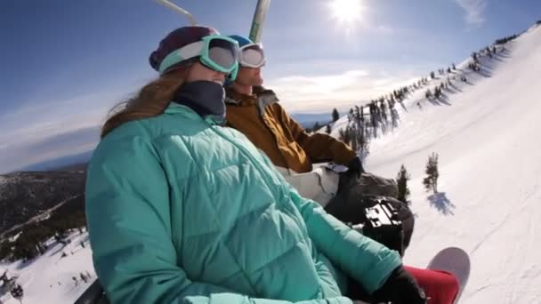 Snowboarders riding up ski lift — Stock Video