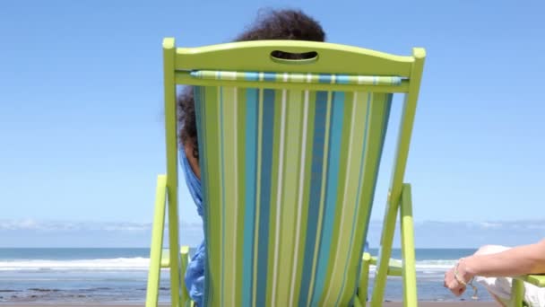 Ζευγάρι, κάθονται σε καρέκλες στην παραλία — Αρχείο Βίντεο