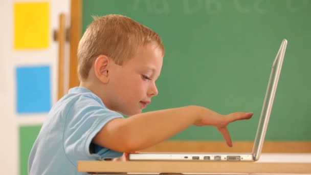 Хлопчик друкує на портативному комп'ютері — стокове відео
