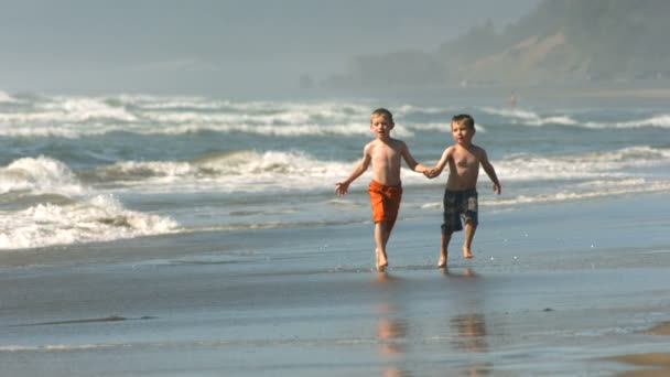 Мальчики бегают по пляжу — стоковое видео
