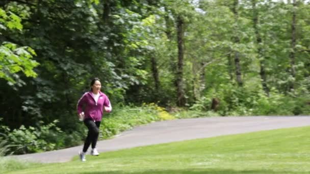 Жінка біжить в парку — стокове відео