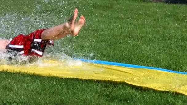 Boy on water slide — Stock Video