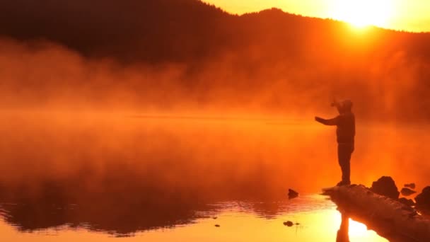 Hombre pescando en el lago — Vídeos de Stock