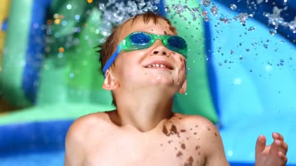 Menino brincando no slide de água — Vídeo de Stock