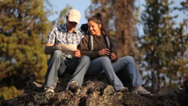 Pareja sentarse en roca — Vídeos de Stock