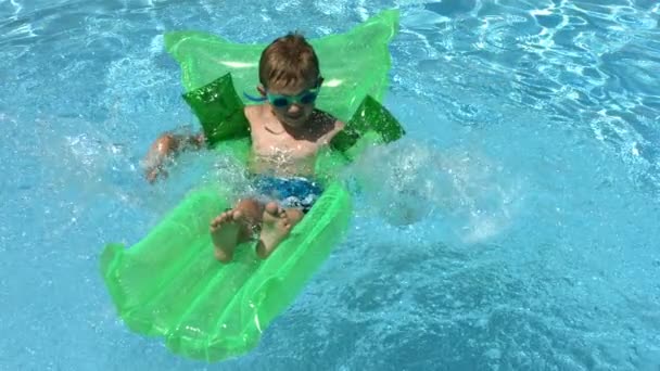 Мальчик плескается в бассейне — стоковое видео
