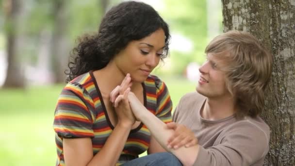 Pareja sentada junto al árbol — Vídeos de Stock