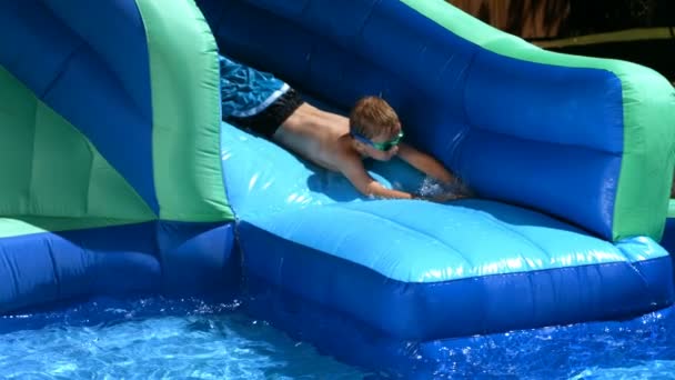 Boy playing on water slide — Stock Video