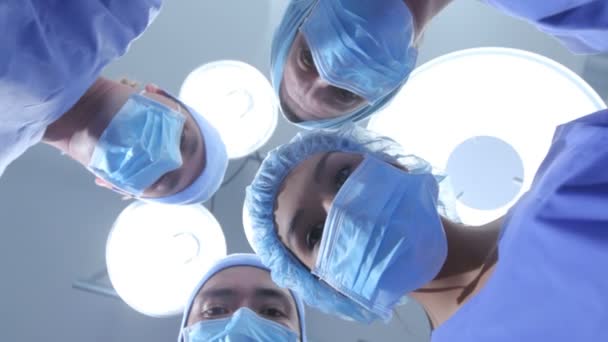 Surgeons look down at patient — Stock Video