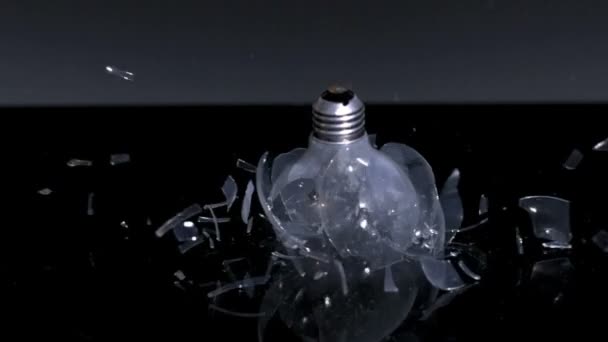 Lightbulb shattering on black background — Stock Video