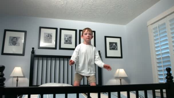 Chico salta en la cama — Vídeos de Stock