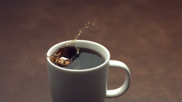 Кубики сахара брызгают в кофе — стоковое видео