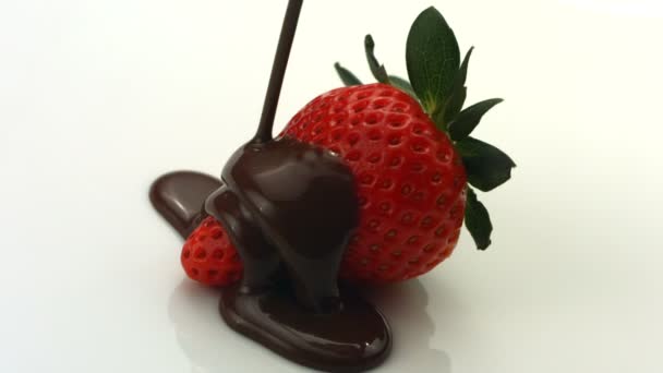 Schokolade tropft auf Erdbeere