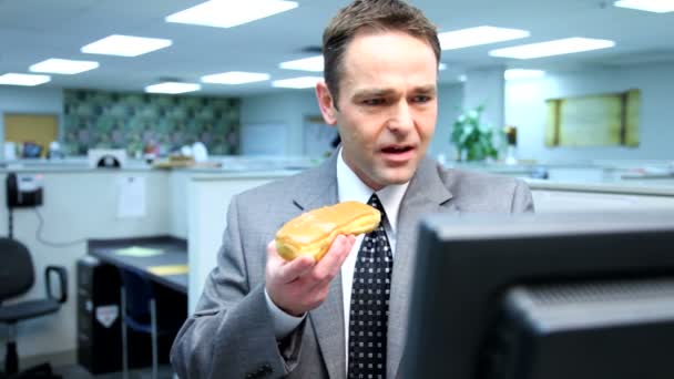 Бизнесмен ест пончики — стоковое видео