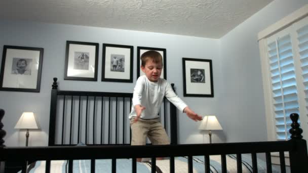 Jongen springt op bed — Stockvideo