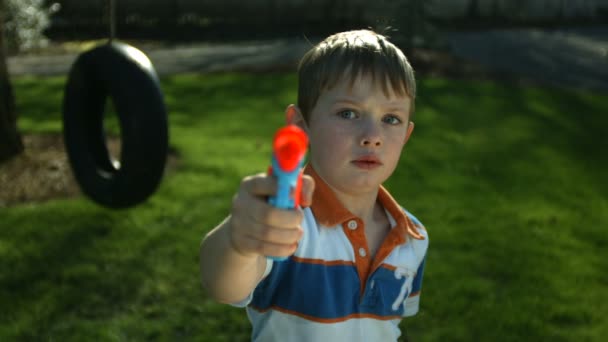 Мальчик распыляет водяной пистолет — стоковое видео