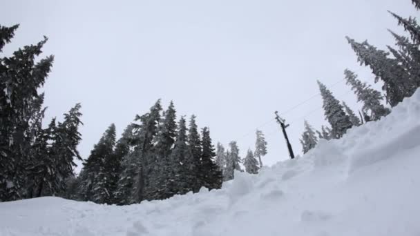 Сноубордист пролетает над холмом — стоковое видео