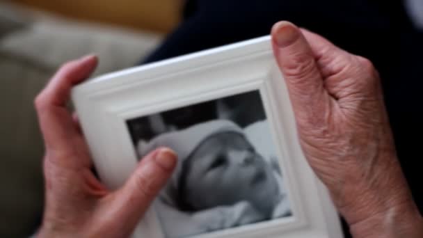 Grand-mère tient photo encadrée — Video