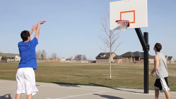 Jugendliche spielen Basketball — Stockvideo