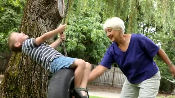 Жінка і хлопчик на гойдалках — стокове відео