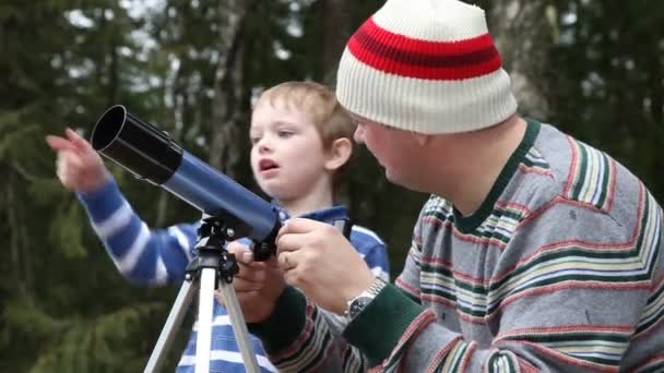 Padre e hijo mirando a través del telescopio — Vídeo de stock