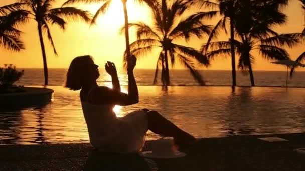 Frau sitzt bei Sonnenuntergang — Stockvideo