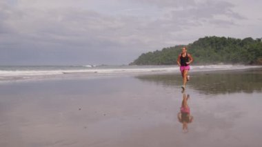 Kumsalda koşan kadın