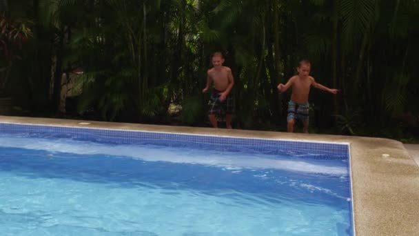 Rapazes a saltar para a piscina — Vídeo de Stock