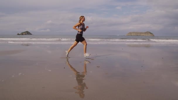 Frau läuft am Strand — Stockvideo