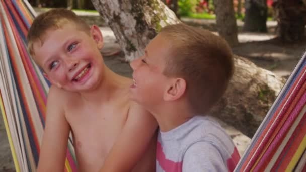 Мальчики сидят в гамаке — стоковое видео