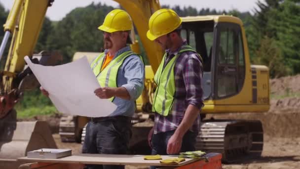 Werknemers op zoek over plannen — Stockvideo