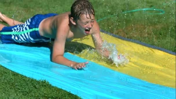 Молодий хлопчик на водяній гірці — стокове відео