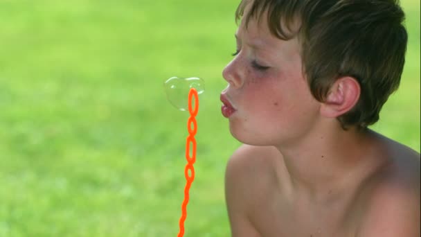 Young boy blowing bubbles — Stock Video