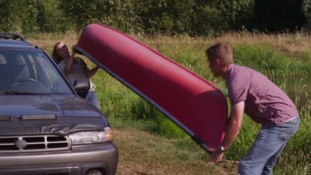 Unloading canoe off car — Stock Video