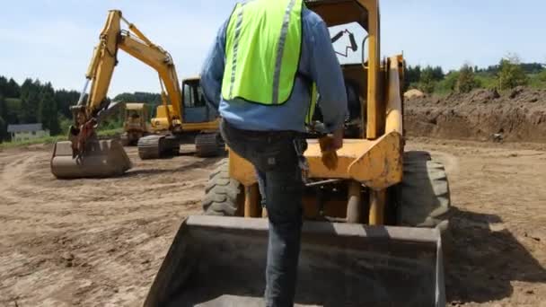 Worker climbing into excavator — Stock Video