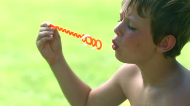 Young boy blowing bubbles — Stock Video
