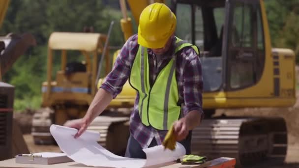 Arbeiter schaut sich Pläne an — Stockvideo