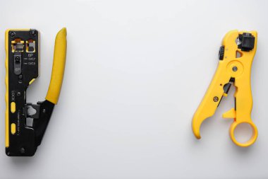 RJ45 çift çiftli sıkıştırıcı ve striptizci beyaz arka planda.