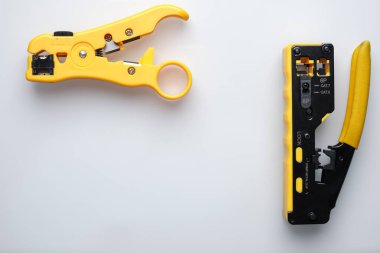 RJ45 çift çiftli sıkıştırıcı ve striptizci beyaz arka planda.
