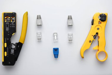 RJ45 çift sıkıştırıcı ve beyaz arkaplanda kablo konnektörlü striptizci.