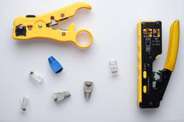 RJ45 çift sıkıştırıcı ve beyaz arkaplanda kablo konnektörlü striptizci.
