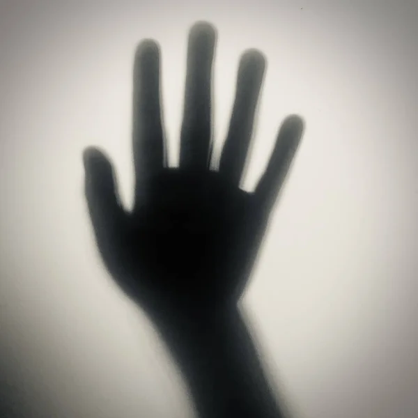 Çocuğun elindeki gölge camın üzerinde.