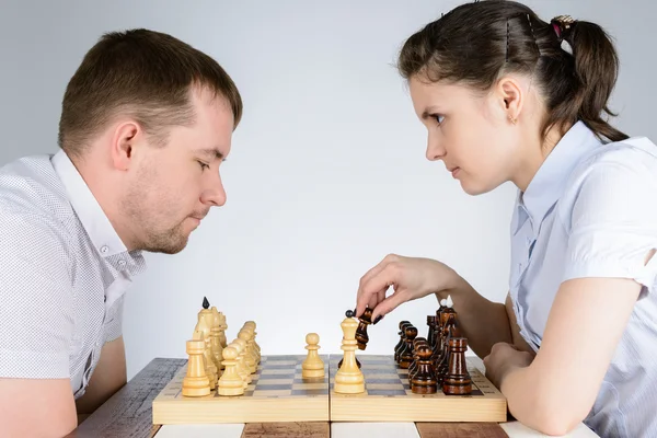 Žena hrající černými kameny v šachy proti mužům — Stock fotografie