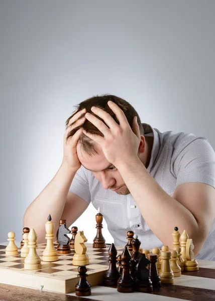 Мужчина думает об игре в шахматы — стоковое фото