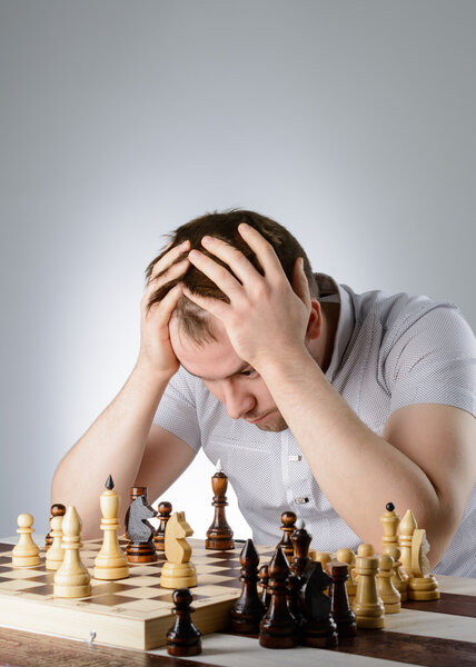 The man is thinking about a game of chess