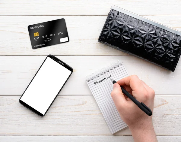 Smartphone, notebook, penna e carta di credito su un tavolo bianco — Foto Stock
